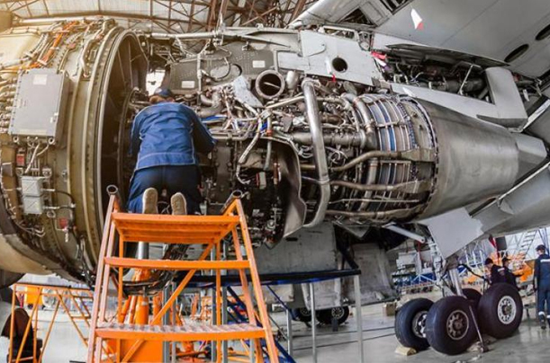 A man diligently works on an airplane engine, showcasing the expertise of Aerospace Engineering Assignment Help