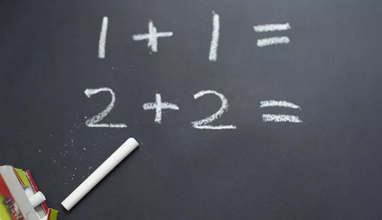 A chalkboard with numbers written on it, providing basic math homework help