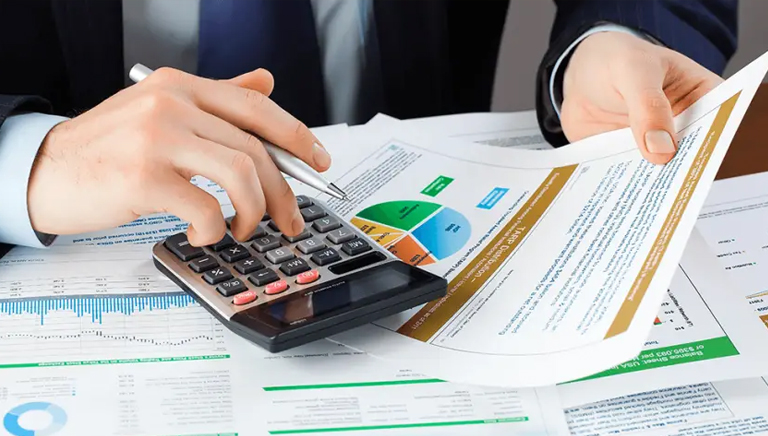 A student in a suit examines financial documents using a calculator, appearing to be engrossed in financial accounting homework and assignment