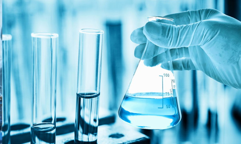 Image of a person assisting with lab work by holding a test tube containing blue liquid