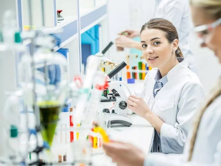 a student looking towards the camera while completing her Laboratory Science Assignment Help