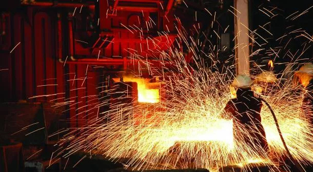 A worker skillfully welds steel in a factory, showcasing the Metallurgy Homework Help