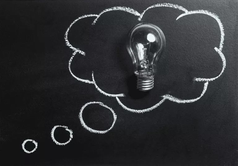 A light bulb with a thought bubble on a blackboard, representing a Numerical Analysis Homework Help concept 