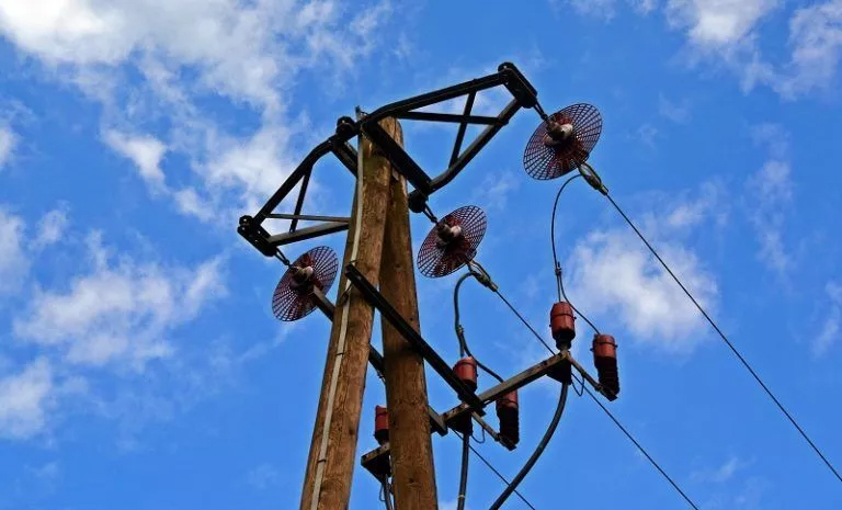 Power pole with wires against a blue sky, representing a physics homework help concept